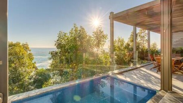 A modern outdoor swimming pool with a clear view of the ocean and surrounding greenery. - Unique Camps Bay Apartment w Private Pool Coral Sea (Cape Town)