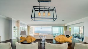 A modern dining area with a large table, chairs, and a unique fish-shaped centerpiece. - Gorgeous Apartment in Secure Block w Sea Views Caliche (Cape Town)