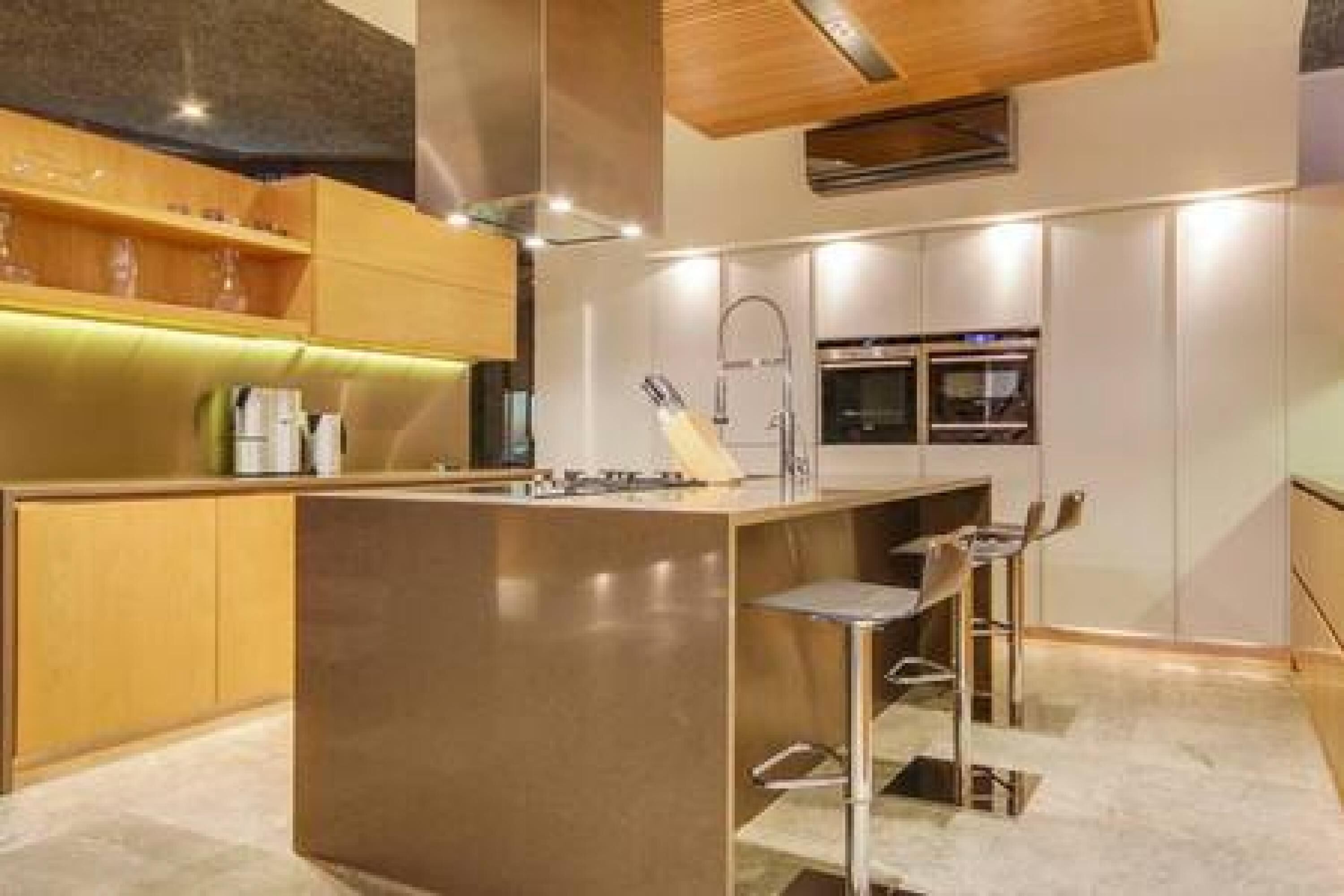 A modern kitchen with a central island, stainless steel appliances, and wooden cabinetry.