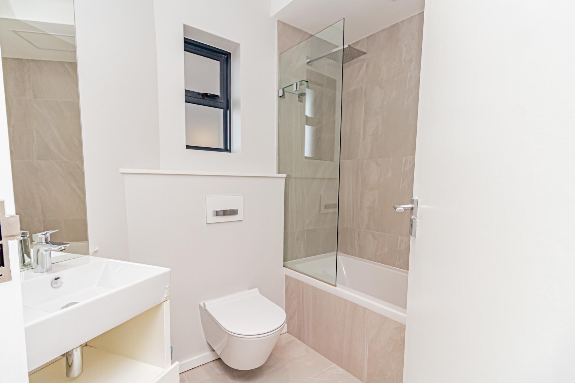 Ein modernes Badezimmer mit Waschbecken, Toilette und einer Duschkabine.
