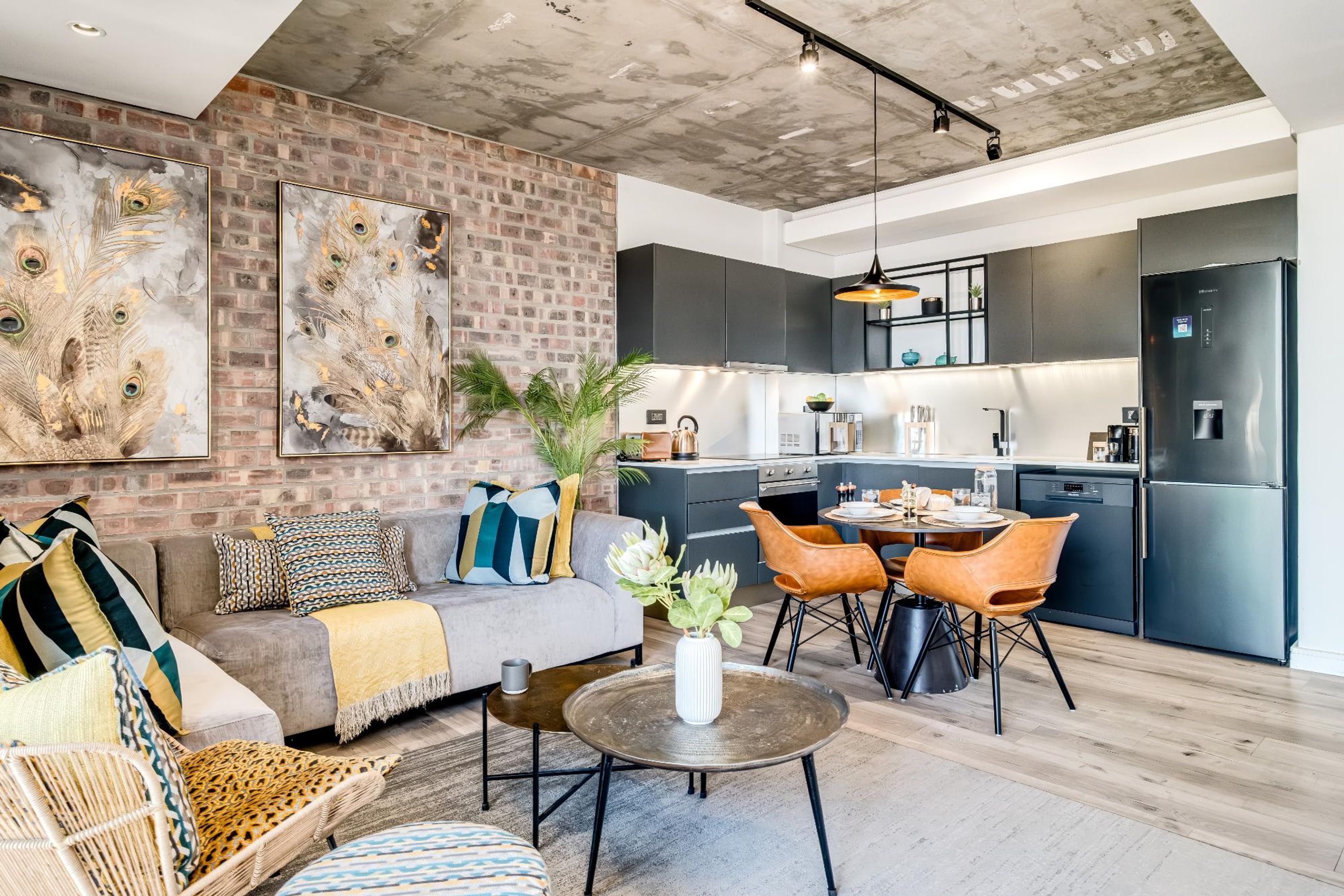 A modern living area with a brick wall, a sofa, a coffee table, and a dining area with chairs.