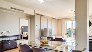 A modern dining area with a glass table, grey chairs, a decorative basket, and a view of the outdoors. - Green Point Apartment Walking Distance to Stadium 407 Royal (Cape Town)