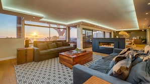 Un salon moderne avec un canapé, une table basse et une cheminée.