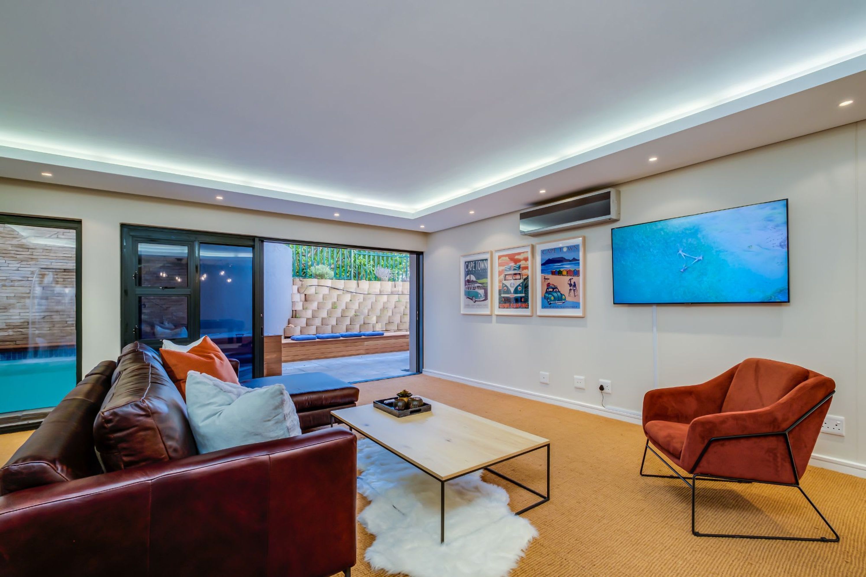 A modern living room with a sofa, coffee table, and a TV mounted on the wall.