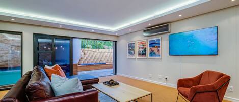 A modern living room with a sofa, coffee table, and a TV mounted on the wall.