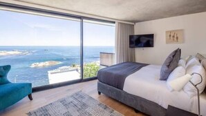 A modern bedroom with a large window offering a view of the sea. - Spectacular Ocean Villa in Camps Bay (Cape Town)