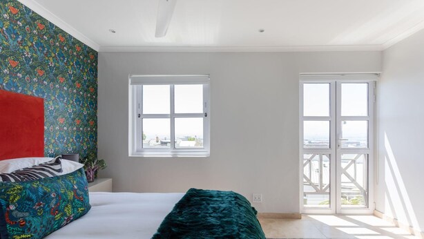 A bedroom with a bed, a window, and a balcony. - Unique City View Apartment in De Waterkant 207 DWP (Cape Town)