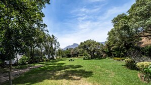 A well-maintained grassy area with trees and a distant mountain view. - Unique City View Apartment in De Waterkant 207 DWP (Cape Town)