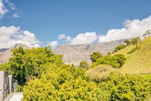 Un paysage montagneux caractérisé par un feuillage verdoyant et luxuriant et un ciel dégagé.