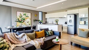 Una sala de estar moderna con un sofá, una mesa de centro y un comedor con una mesa y sillas.