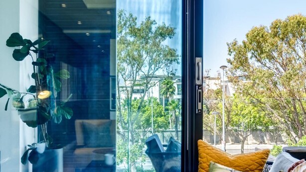 Una sala de estar moderna con un sofá, una mesa de centro y vistas al exterior.