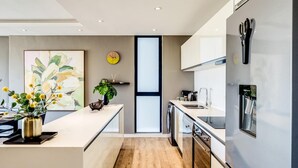 Una cocina moderna con una isla central, lavavajillas y un refrigerador con dispensador de agua.