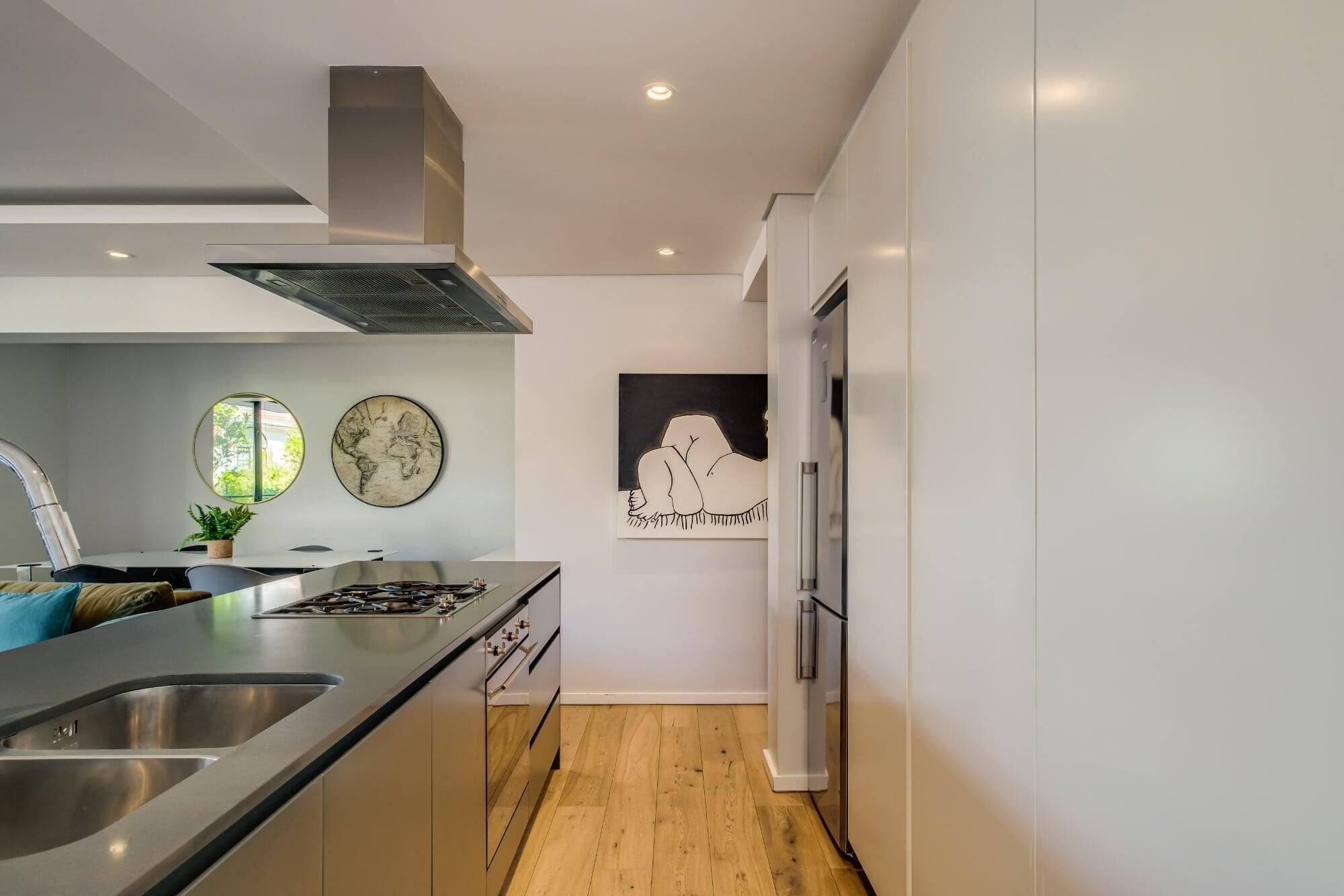 A modern kitchen with stainless steel appliances, a large island, and minimalist decor.
