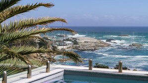 Piscina com vista para o oceano e costa rochosa.