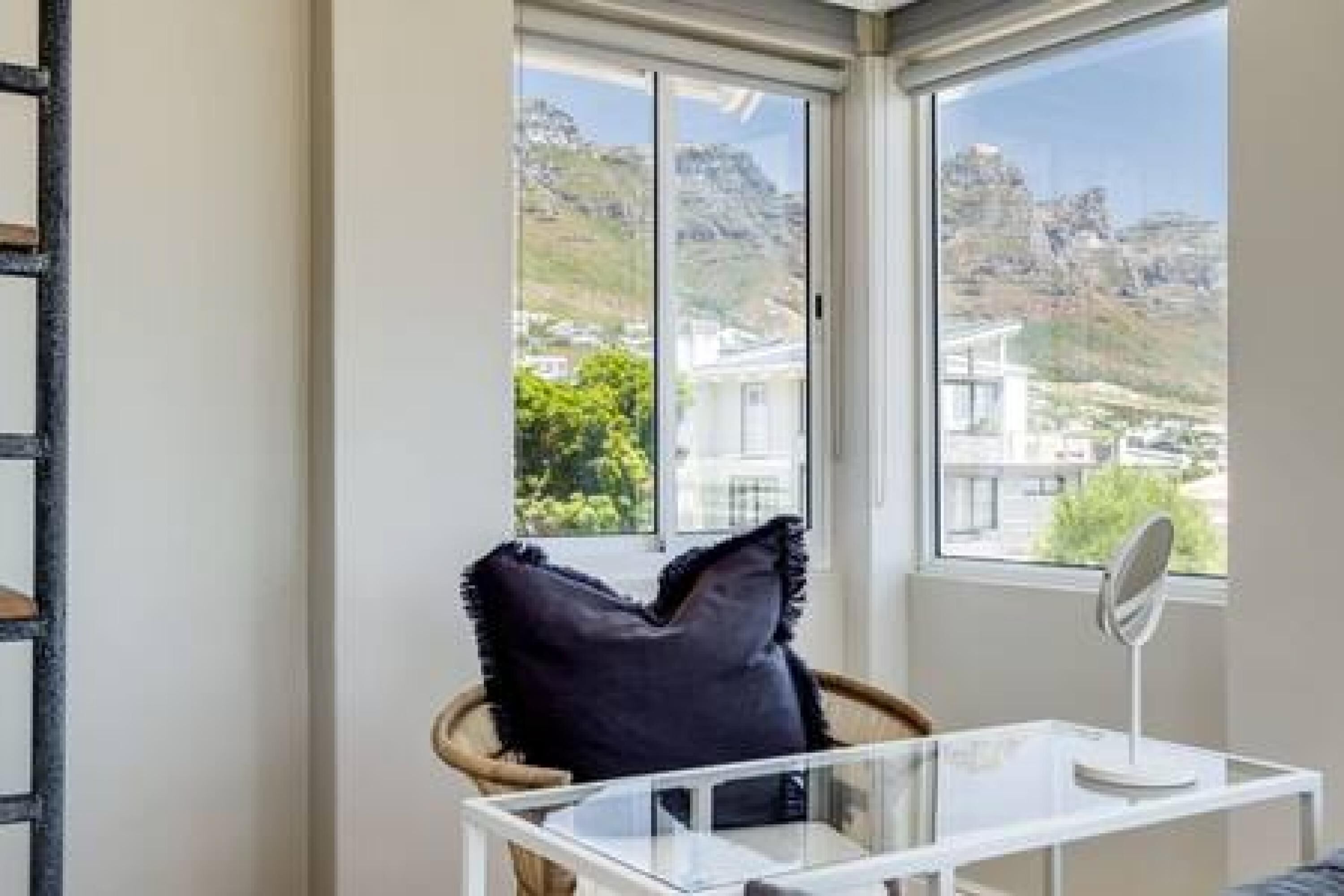 Ein Zimmer mit einem großen Fenster und Blick auf eine gebirgige Landschaft.