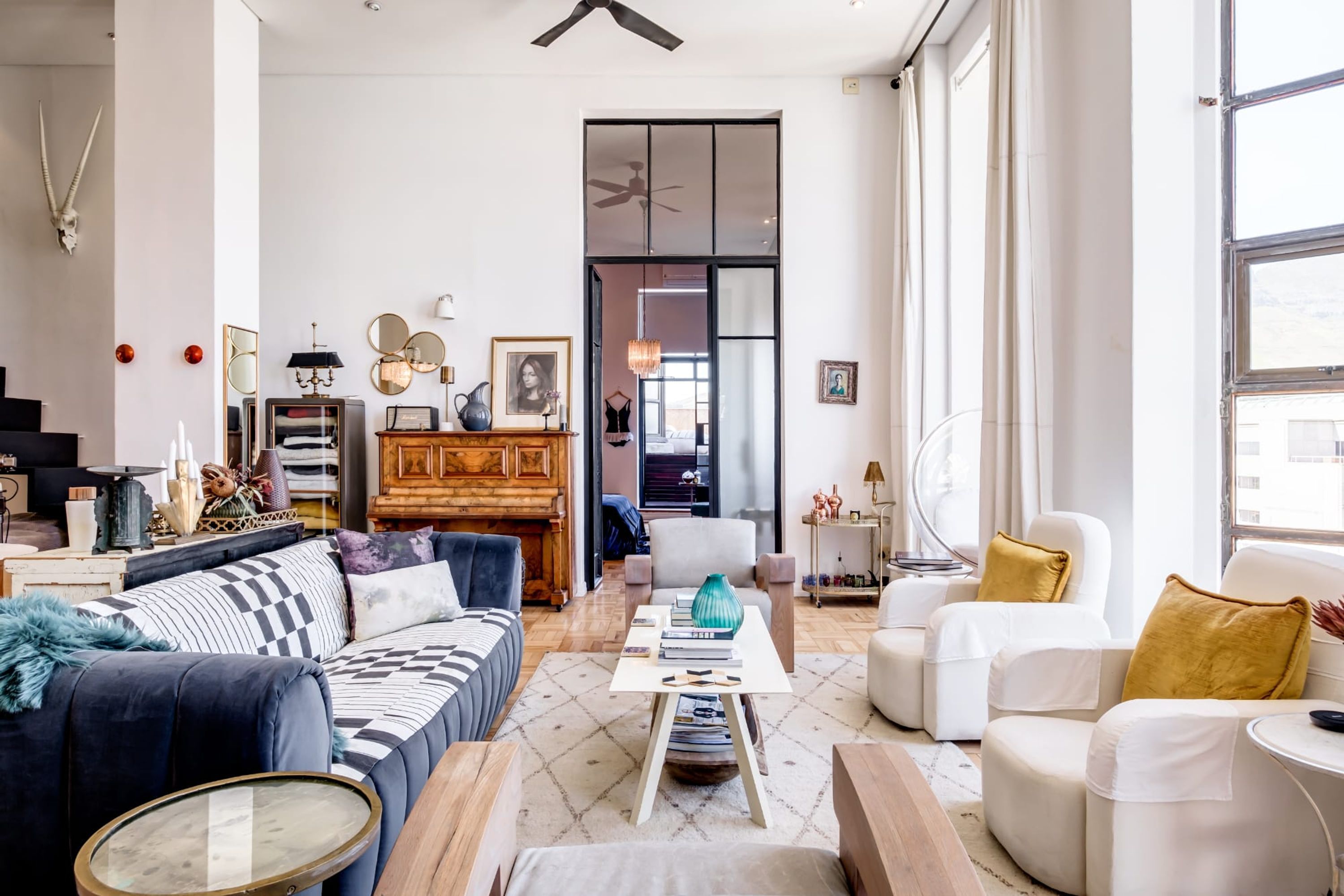 A spacious living room with a sofa, armchairs, a coffee table, and a fireplace.