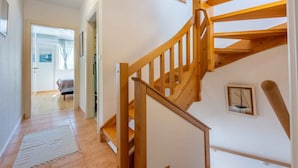 A wooden staircase with a handrail, leading to a bedroom with a bed and a window. - Holiday apartment with dishwasher and washing machine (Selce)