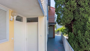 A narrow corridor with a white door, a light fixture, and a metal railing. - Holiday apartment with dishwasher and washing machine (Selce)