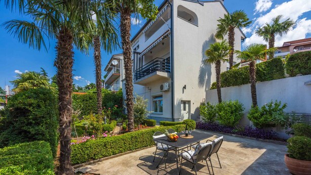 A modern building with balconies, surrounded by well-maintained gardens and palm trees. - Studio with terrace and air conditioning (Crikvenica)