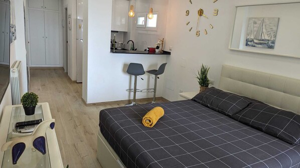 A modern bedroom with a bed, a small desk, and a kitchenette. - Comfortable Studio in Marbella With sea Views (Marbella)