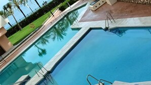 A rectangular pool with clear blue water, surrounded by a tiled deck. - Comfortable Studio in Marbella With sea Views (Marbella)