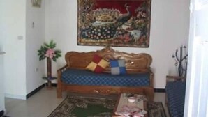Un salon avec un canapé, une table basse et un tableau accroché au mur.
