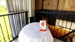 A small table with a white tablecloth on a balcony with metal railings. A brochure titled "What's on Your Mind?" is placed on the table.
