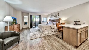 Ein Schlafzimmer mit Bett, Schreibtisch, Stuhl, Kommode und Fenster.