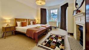 A hotel room with two beds, a fireplace, a large window, and a view of the outside. - Stunning Family Home in Tulse Hill (London)