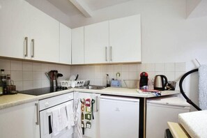 Enjoy cooking in this fully equipped kitchen with oven, refrigerator, and sink.