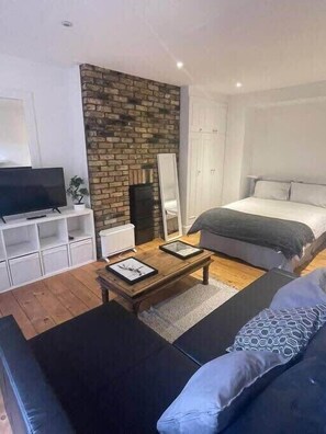 Relax in this serene bedroom with a large bed, flat-screen TV, and cozy coffee table.