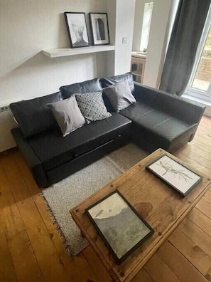 Relax in this inviting living space with a comfortable sofa, coffee table, and wall-mounted shelf.