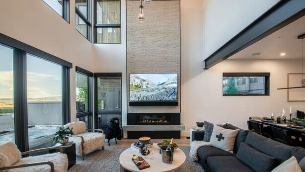 Uma sala de estar moderna com lareira, uma televisão grande e um espaço de estar acolhedor.