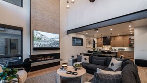 Uma sala de estar moderna com lareira, uma TV grande e um espaço de estar aconchegante.