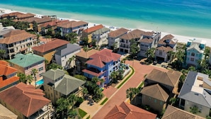 A coastal residential area with houses, a beach, and a clear view of the ocean.