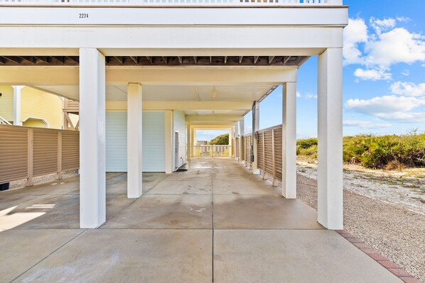A covered walkway with white columns, leading to a building with a number 2234. - Rest Assured: Beachfront in Plantation, Private Pool, Pool Table (St. George Island)