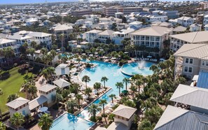 A resort with a large central pool surrounded by multiple-story buildings, palm trees, and a well-maintained lawn. - Seacrest Beach + Near Beach, Fire Pit, Sleeps 12 (Seacrest Beach)