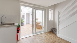 A modern kitchen with a sink, a fire extinguisher, and a potted plant. - Cosy Gem in Covent Garden (London)
