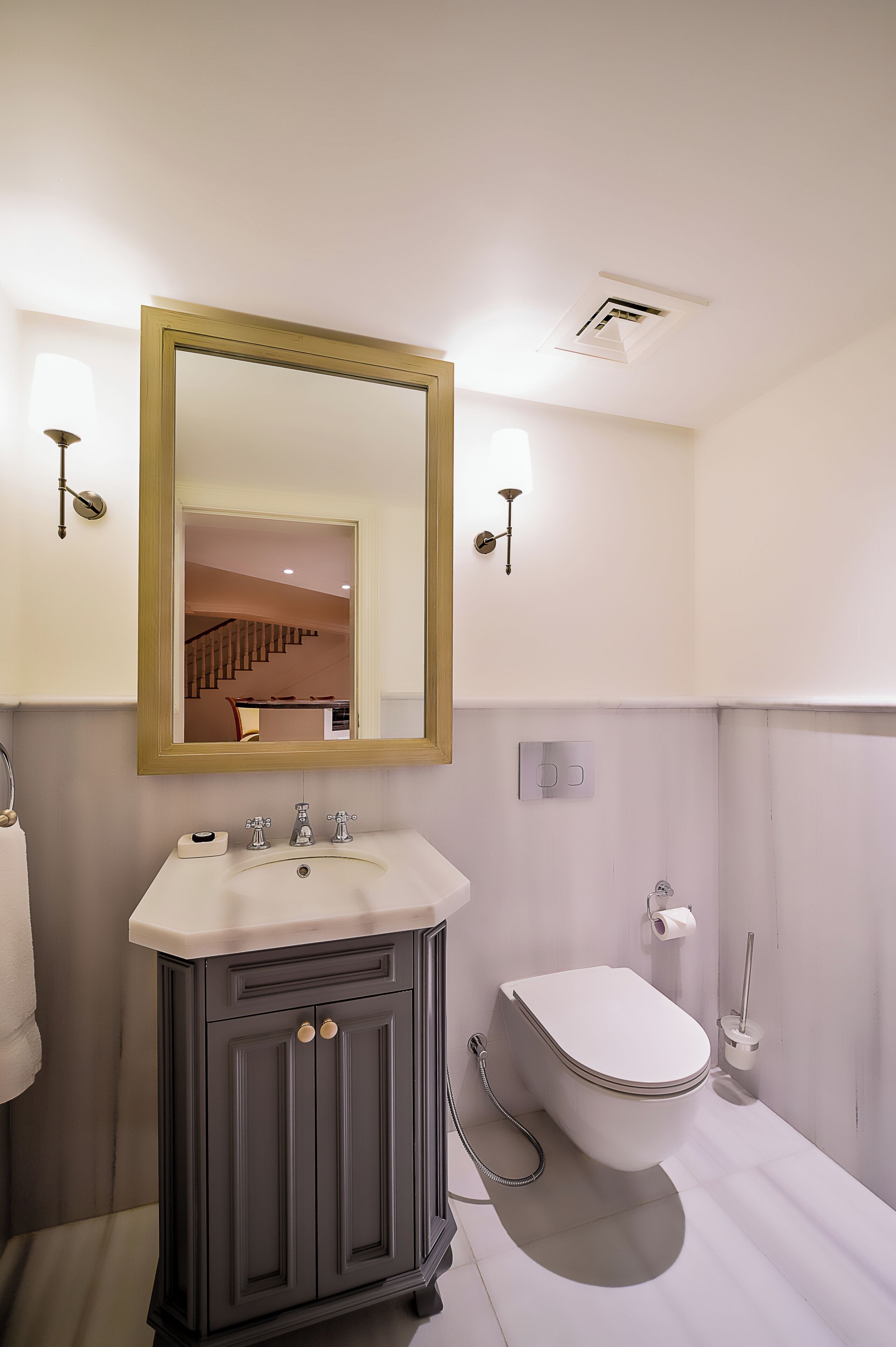 Ein modernes Badezimmer mit Waschtisch, Toilette und einem großen Spiegel.