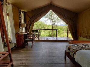 A tented room with a bed, a desk, and a chair. - Oldonyo Orok Camp  (Kajiado)