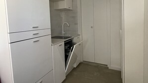 A compact kitchen with white cabinetry, a built-in dishwasher, and a sink. - Little Aventino BnB - in the heart of Rome (Roma)