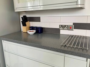 Eine Küche mit Arbeitsplatte, Kaffeemaschine, einer Schüssel und einem Wasserkocher.
