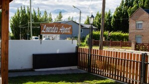 Ein verschlossener Eingang zu einem Gebäude, an dem ein Schild mit der Aufschrift 'Lourdes Apart' steht.