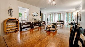 A spacious dining area with a wooden table and chairs, a decorative house model, and pendant lighting. - Perfect location. Home away from home. (Mont-Tremblant)