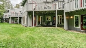 A two-story house with a covered patio area and a small outdoor seating space. - Perfect location. Home away from home. (Mont-Tremblant)