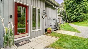 A residential house with a red door, white-framed windows, and a front porch with a white picket fence. - Perfect location. Home away from home. (Mont-Tremblant)