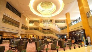 A spacious lobby with a grand chandelier, multiple seating areas, and a central staircase. - Huangyan Yaoda Hotel (Taizhou)