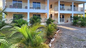 A multi-story hotel with balconies, surrounded by tropical plants. - Bella Villa large apart for 4 with pool, jacuzzi @ 5 min walk to beach! (Samaná)