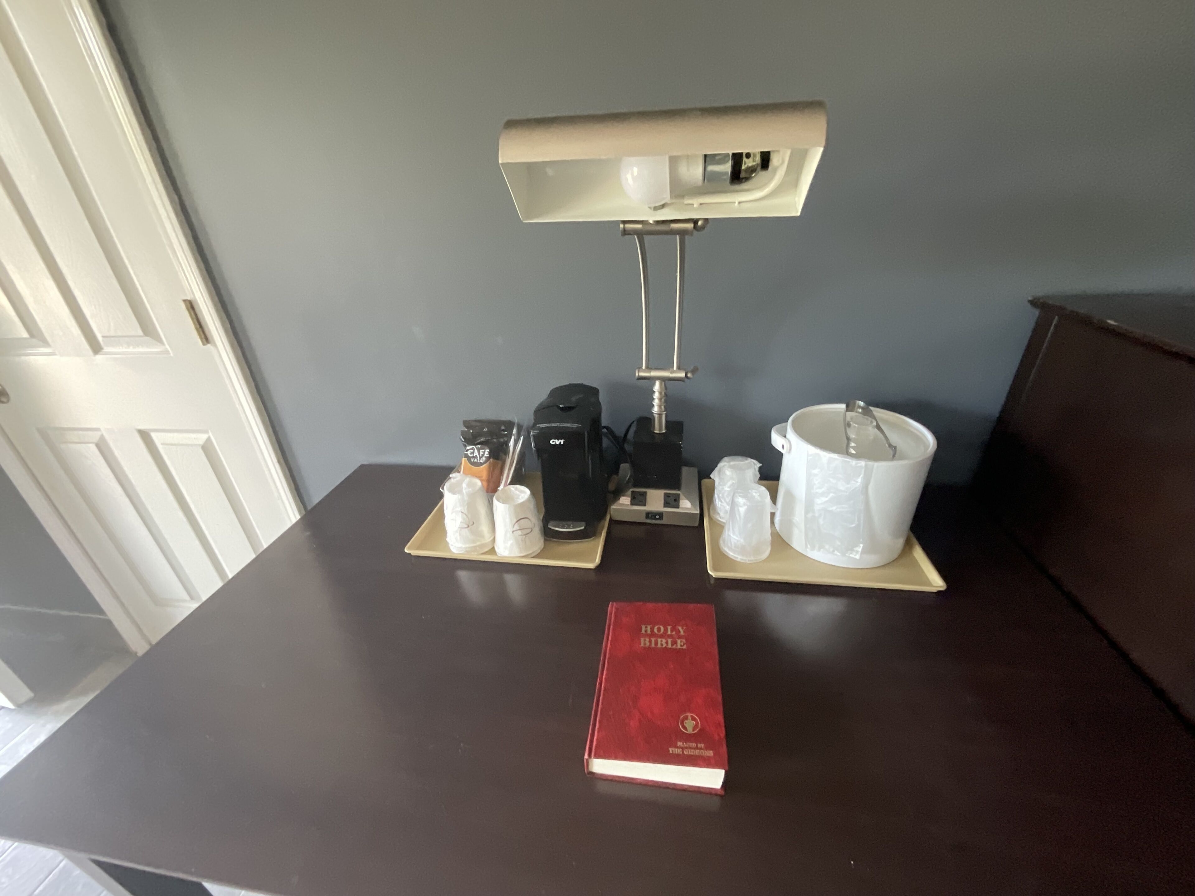 Ein Tisch mit einer Kaffeemaschine, einer Tasse, einem Becher, einer Kanne und einem Buch.