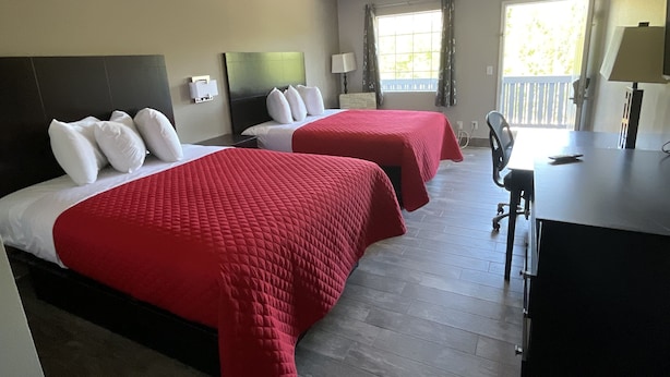 Une chambre d’hôtel avec deux lits, un bureau et une chaise.